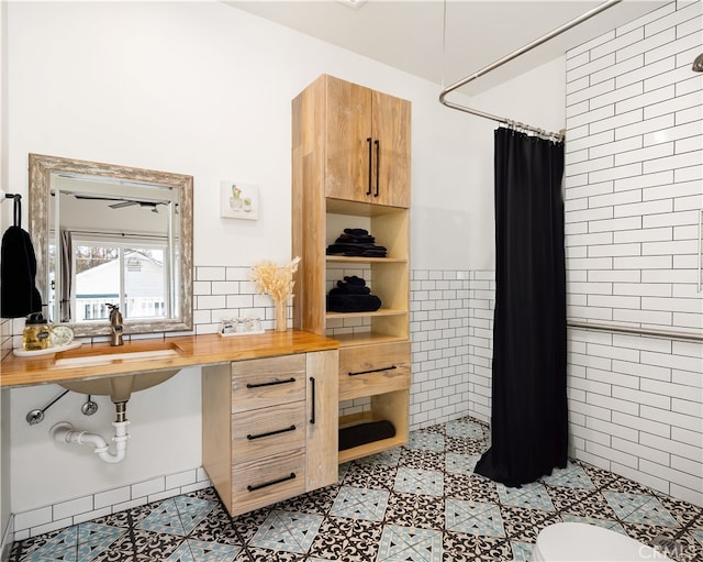 kitchen with wooden counters, tile walls, and sink