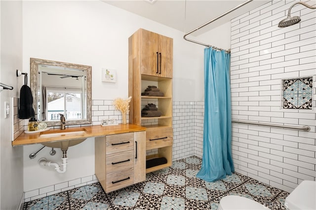 bathroom with toilet, tile walls, sink, and a shower with curtain