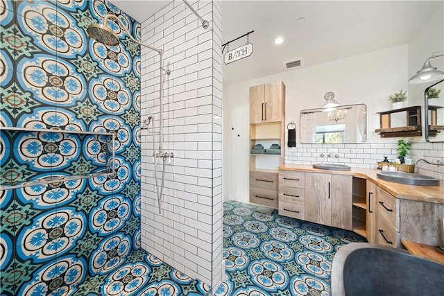 bathroom featuring a tile shower, backsplash, and vanity