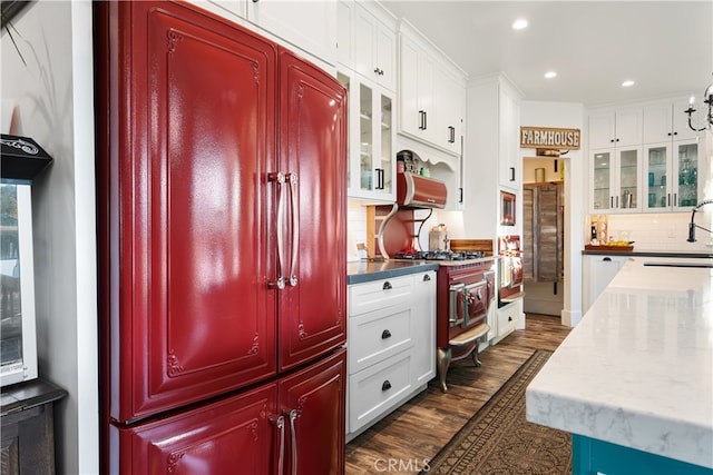 kitchen featuring sink, stainless steel gas cooktop, white cabinets, decorative backsplash, and dark hardwood / wood-style floors