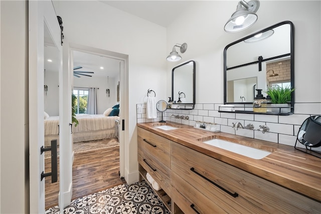 bathroom with vanity, hardwood / wood-style floors, backsplash, and ceiling fan