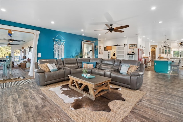 living room featuring wood-type flooring, plenty of natural light, and a barn door