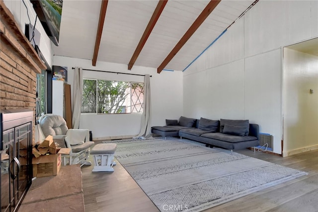 living room featuring wood-type flooring, beam ceiling, and high vaulted ceiling