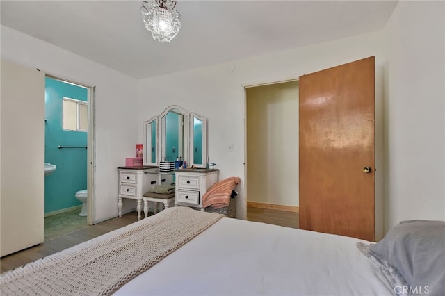 bedroom with light wood-type flooring and ensuite bathroom