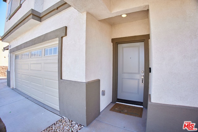 doorway to property with a garage