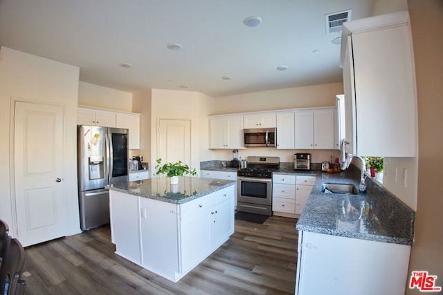 kitchen featuring stainless steel appliances, sink, a center island, white cabinets, and dark hardwood / wood-style flooring