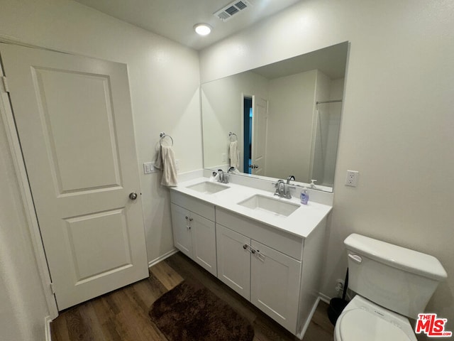 bathroom with vanity, hardwood / wood-style flooring, and toilet