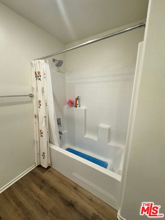 bathroom with shower / bath combo with shower curtain and hardwood / wood-style floors