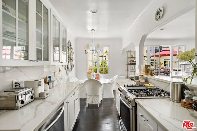 kitchen with decorative backsplash, light stone countertops, stainless steel appliances, dark wood-type flooring, and hanging light fixtures