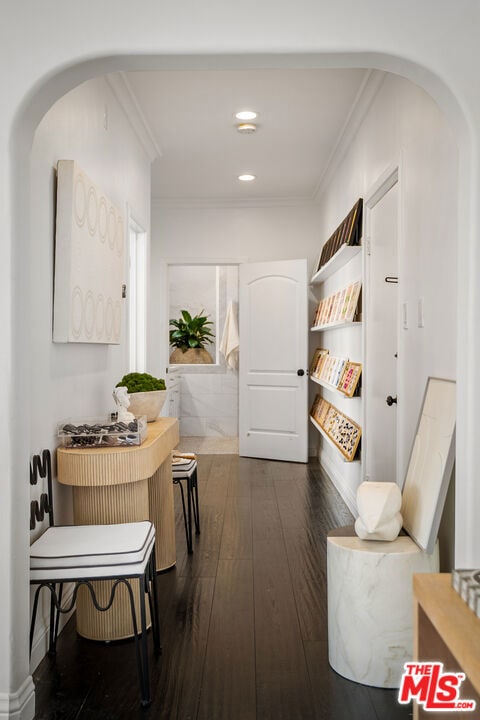 hallway featuring dark wood-type flooring and ornamental molding