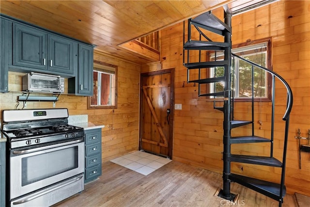 kitchen with light wood-type flooring, wood ceiling, wood walls, and gas range