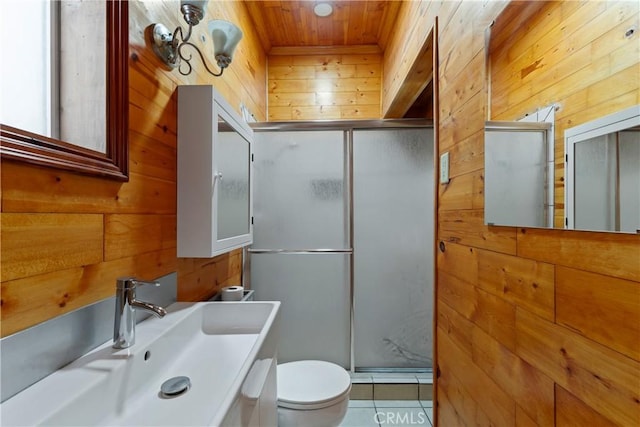 bathroom with tile patterned floors, vanity, wood walls, and an enclosed shower