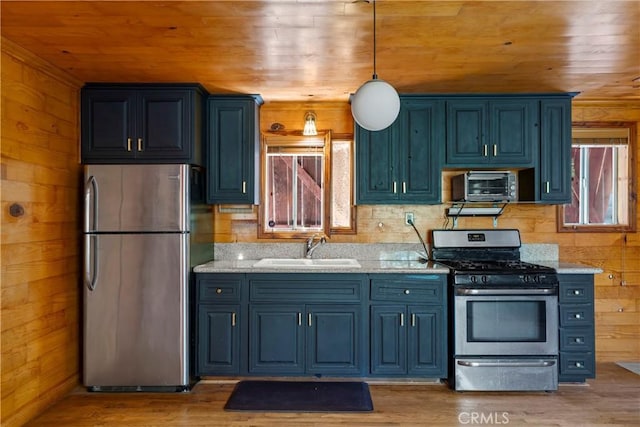 kitchen featuring sink, appliances with stainless steel finishes, wood ceiling, and wooden walls