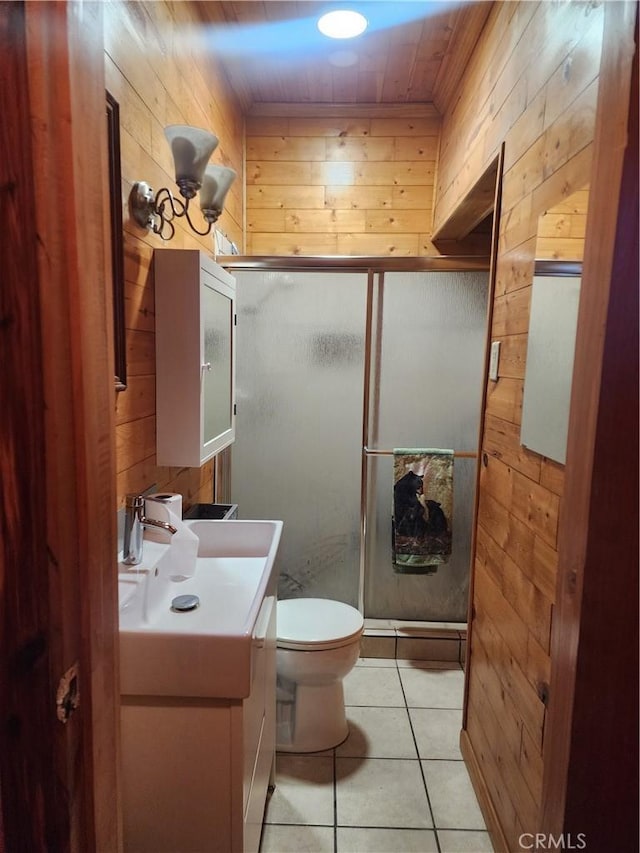 bathroom featuring a shower with shower door, tile patterned floors, vanity, and wooden walls