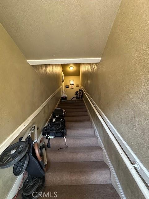 staircase featuring a textured ceiling