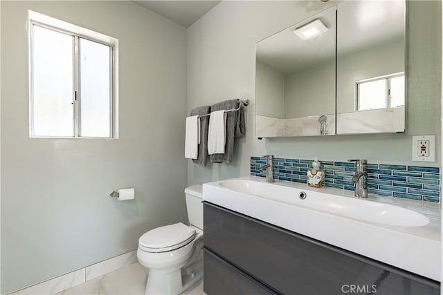 bathroom with toilet, decorative backsplash, and vanity