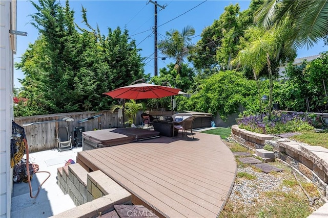 wooden terrace featuring a covered hot tub and a patio