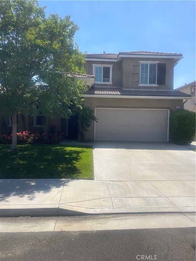 view of front of home with a front yard and a garage