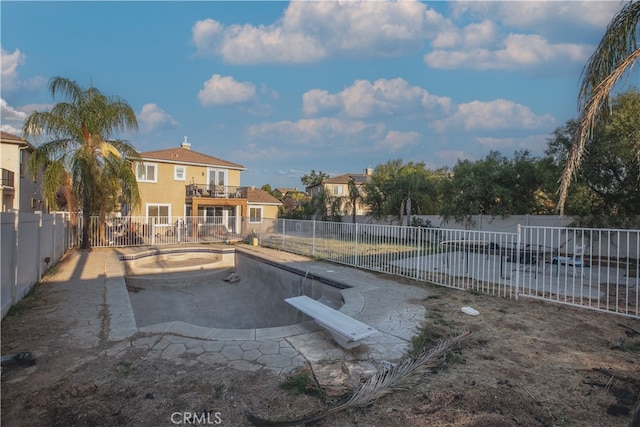 view of pool with a diving board and a patio