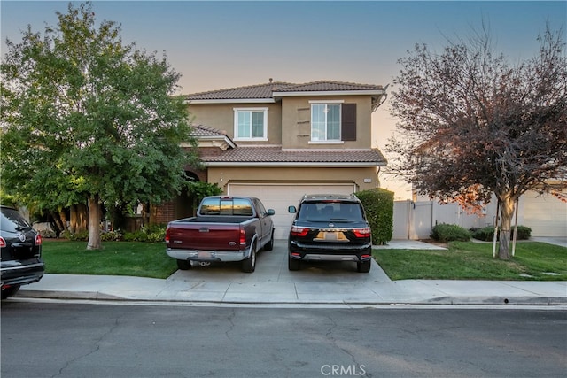 mediterranean / spanish-style home with a yard and a garage