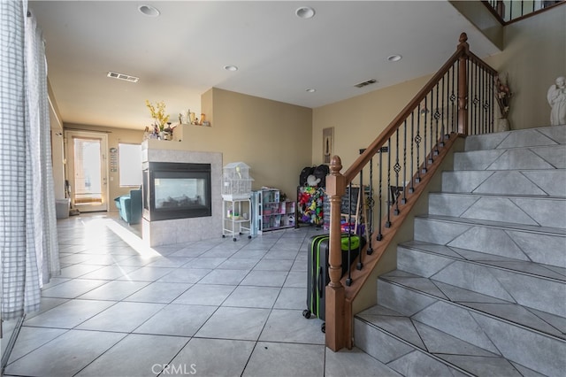 stairs featuring a tiled fireplace and tile patterned floors