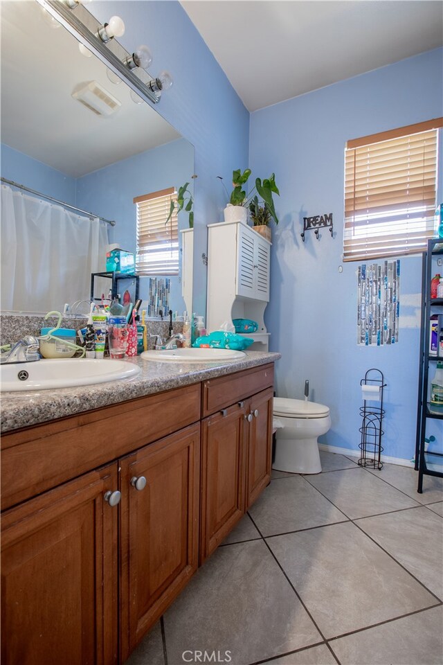 bathroom with tile patterned floors, vanity, toilet, and a shower with shower curtain