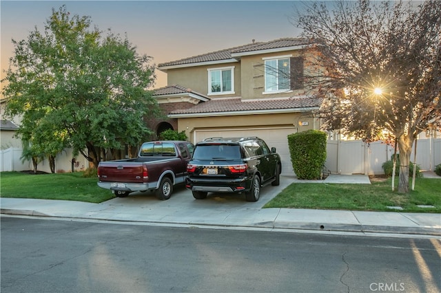 view of front of property with a garage and a lawn