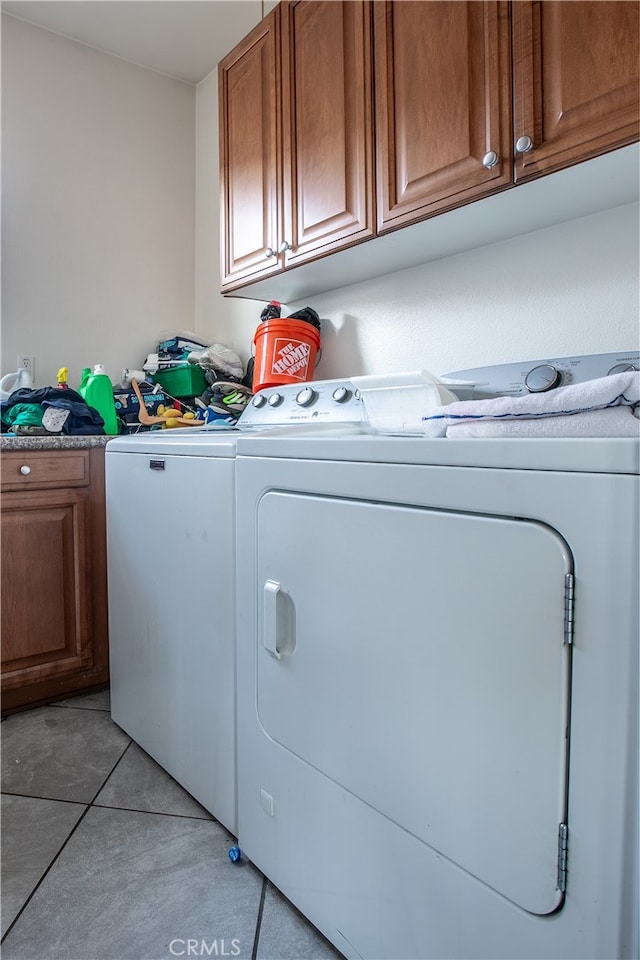 washroom featuring light tile patterned flooring, cabinets, and separate washer and dryer