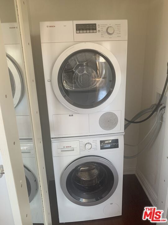 clothes washing area with stacked washer / dryer