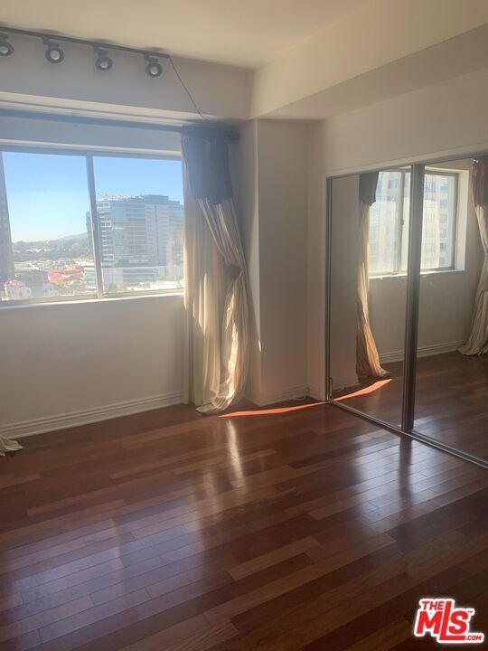 unfurnished room with a wealth of natural light and dark hardwood / wood-style floors