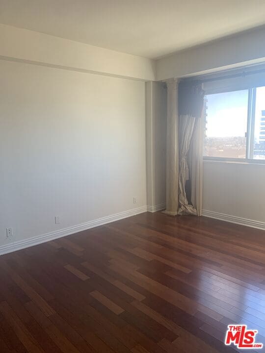 unfurnished room with dark hardwood / wood-style floors