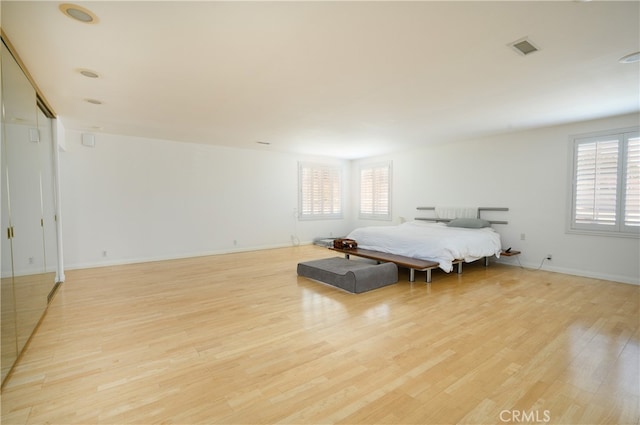 bedroom with light hardwood / wood-style flooring and multiple windows