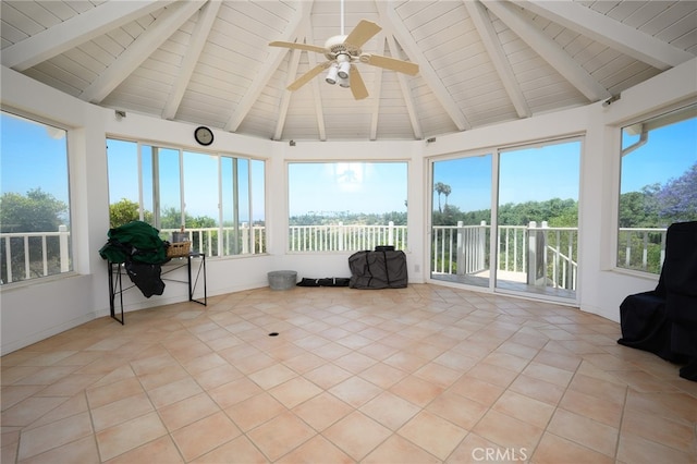 unfurnished sunroom featuring vaulted ceiling with beams, ceiling fan, and a wealth of natural light