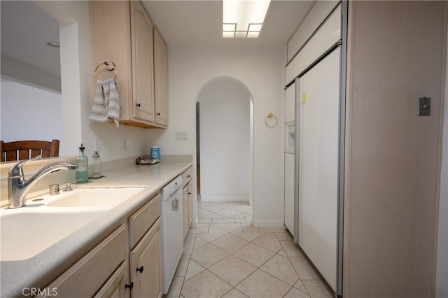 kitchen featuring sink, white dishwasher, and light tile patterned floors