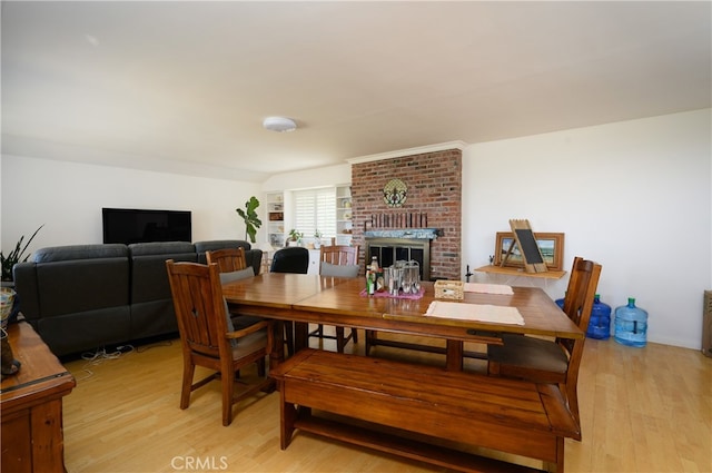 dining room featuring a fireplace and light wood-type flooring