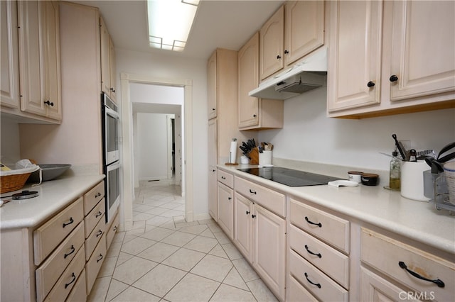 kitchen featuring black electric stovetop, light tile patterned flooring, light brown cabinetry, and stainless steel double oven