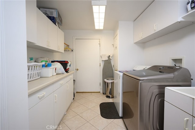 washroom with cabinets, independent washer and dryer, and light tile patterned floors