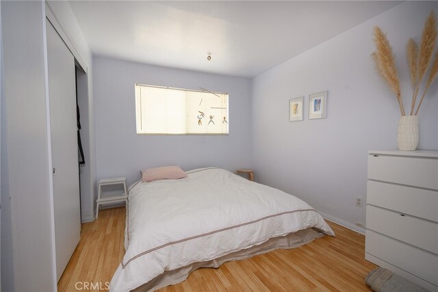 bedroom with a closet and light hardwood / wood-style floors