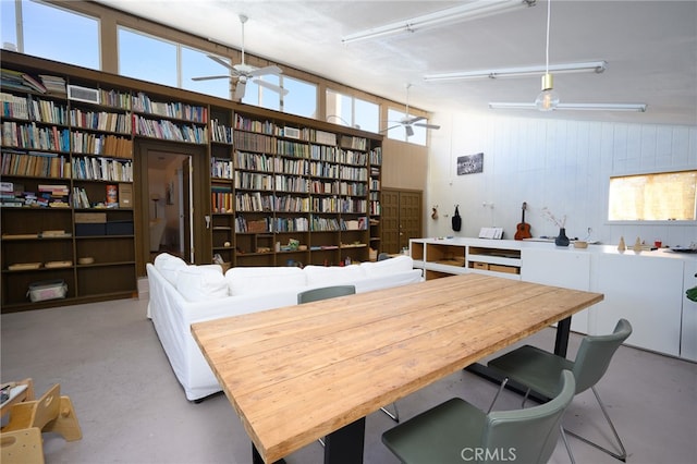 interior space featuring wooden walls, high vaulted ceiling, and ceiling fan