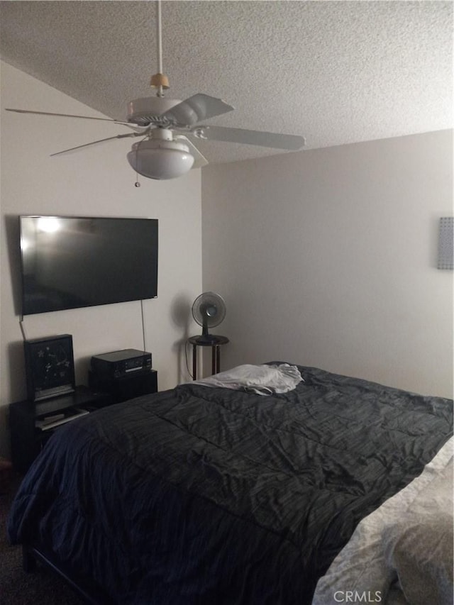 bedroom featuring ceiling fan, a textured ceiling, and lofted ceiling