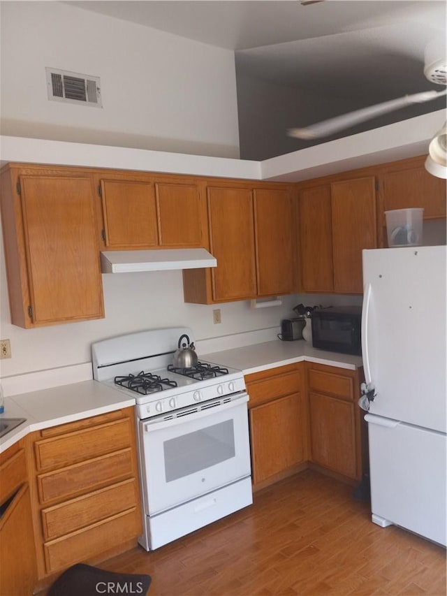 kitchen featuring light hardwood / wood-style floors and white appliances