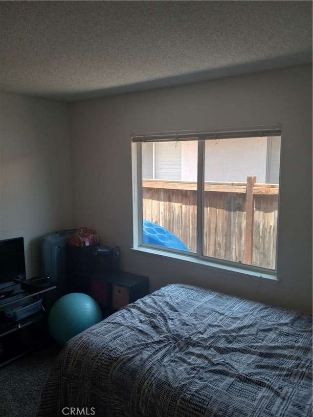 bedroom featuring a textured ceiling and multiple windows