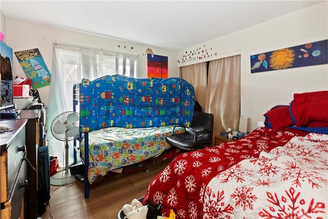 bedroom featuring a textured ceiling and wood-type flooring