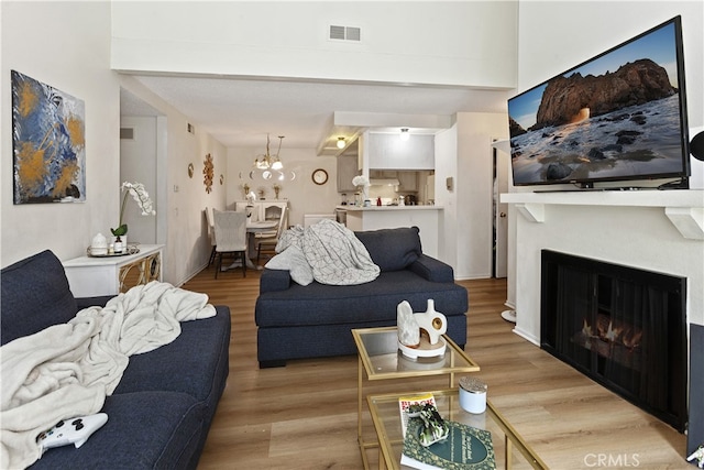 living room featuring an inviting chandelier and wood-type flooring