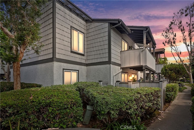 property exterior at dusk with a balcony