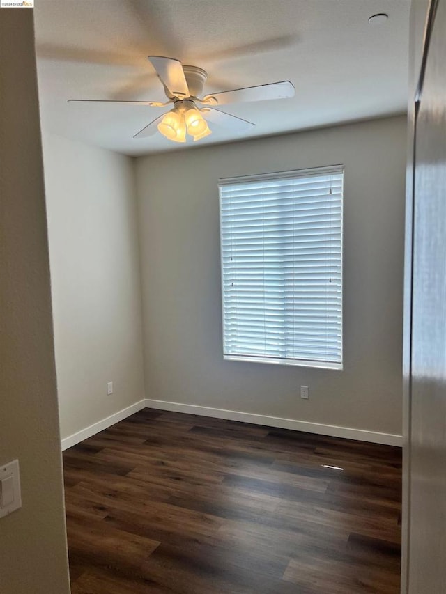 spare room with ceiling fan and dark wood-type flooring