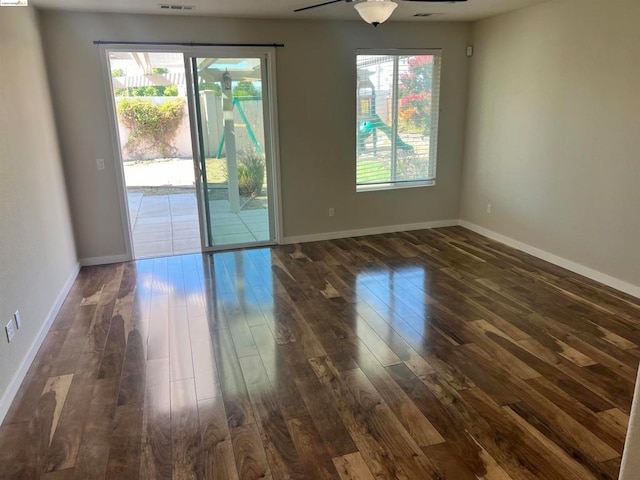 unfurnished room with ceiling fan and dark hardwood / wood-style flooring