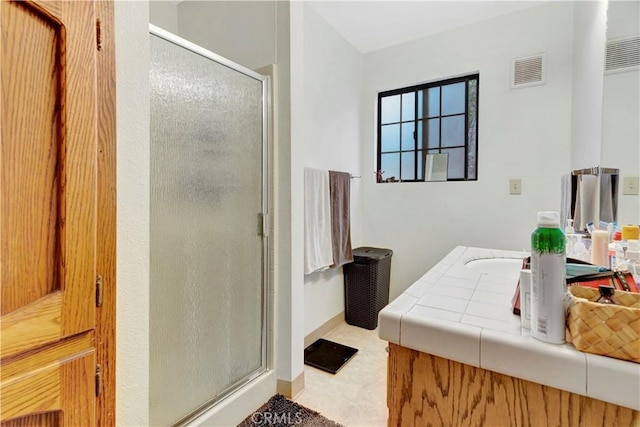 bathroom with vanity and a shower with door