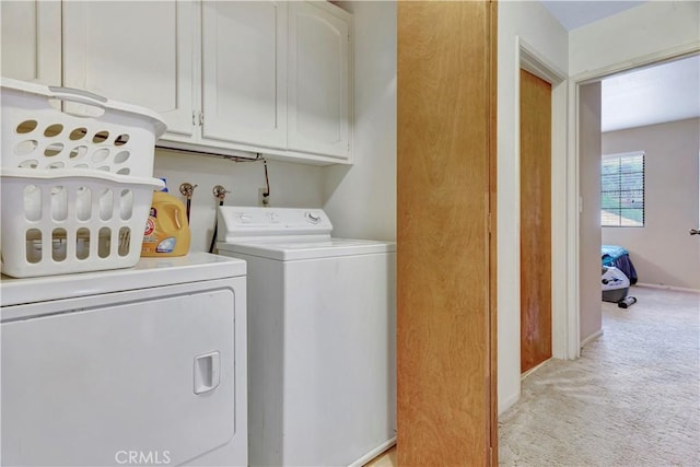 laundry room featuring cabinets, light colored carpet, and washer and clothes dryer