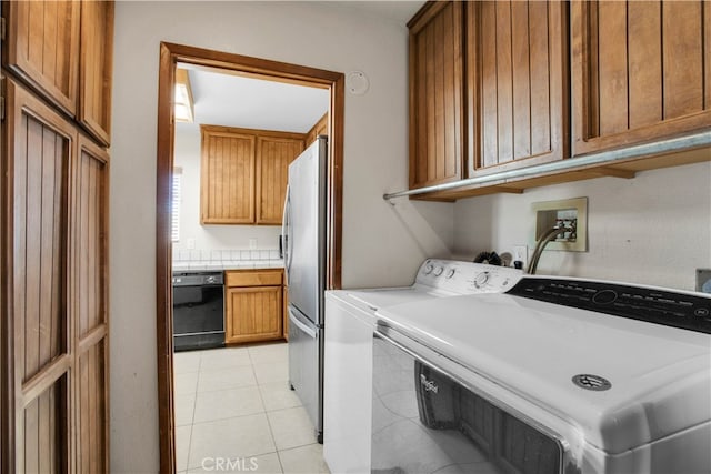 laundry area with light tile patterned flooring, independent washer and dryer, and cabinets